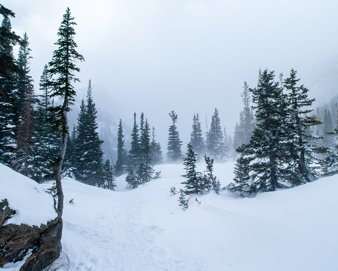 A snow covered trail leads up to subalpine lakes